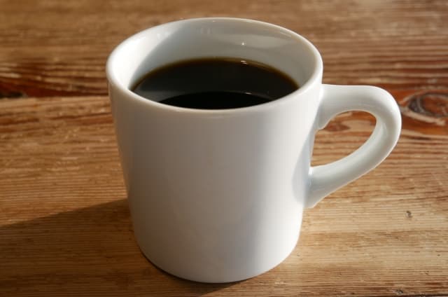 机の上にあるコップ一杯のコーヒー